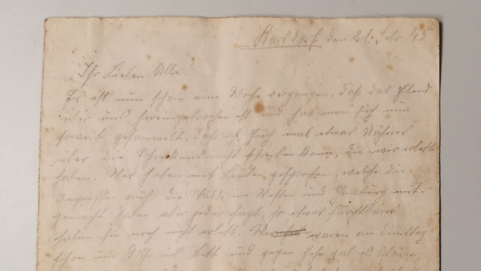 KI generiert: Das Bild zeigt einen handgeschriebenen Brief auf vergilbtem Papier, der mit Tinte geschrieben ist und sichtbare Altersflecken aufweist. Der Text ist in Kurrentschrift verfasst und die Seite ist in der Mitte gefaltet.