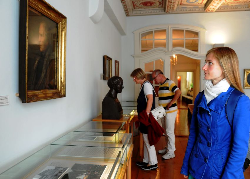 Besucher in der Ausstellung. Eine junge Frau betrachtet ein Portrait von Caspar David Friedrich.